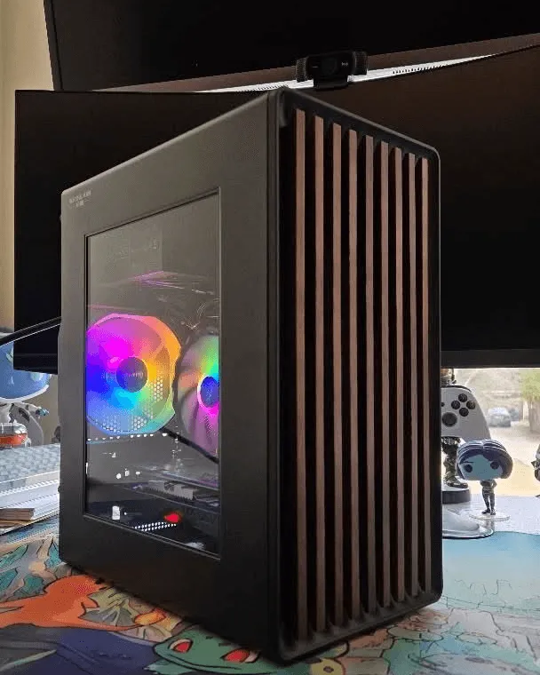Black compact case with walnut wood-slat front panel and rainbow CPU fan