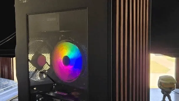 Black compact case with walnut wood-slat front panel and rainbow RGB fans